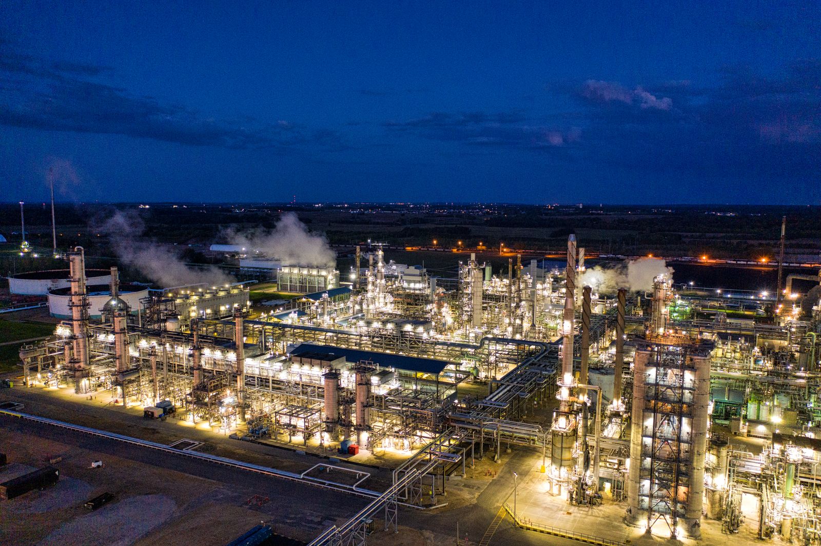 Impianto di raffinazione petrolifera illuminato di notte