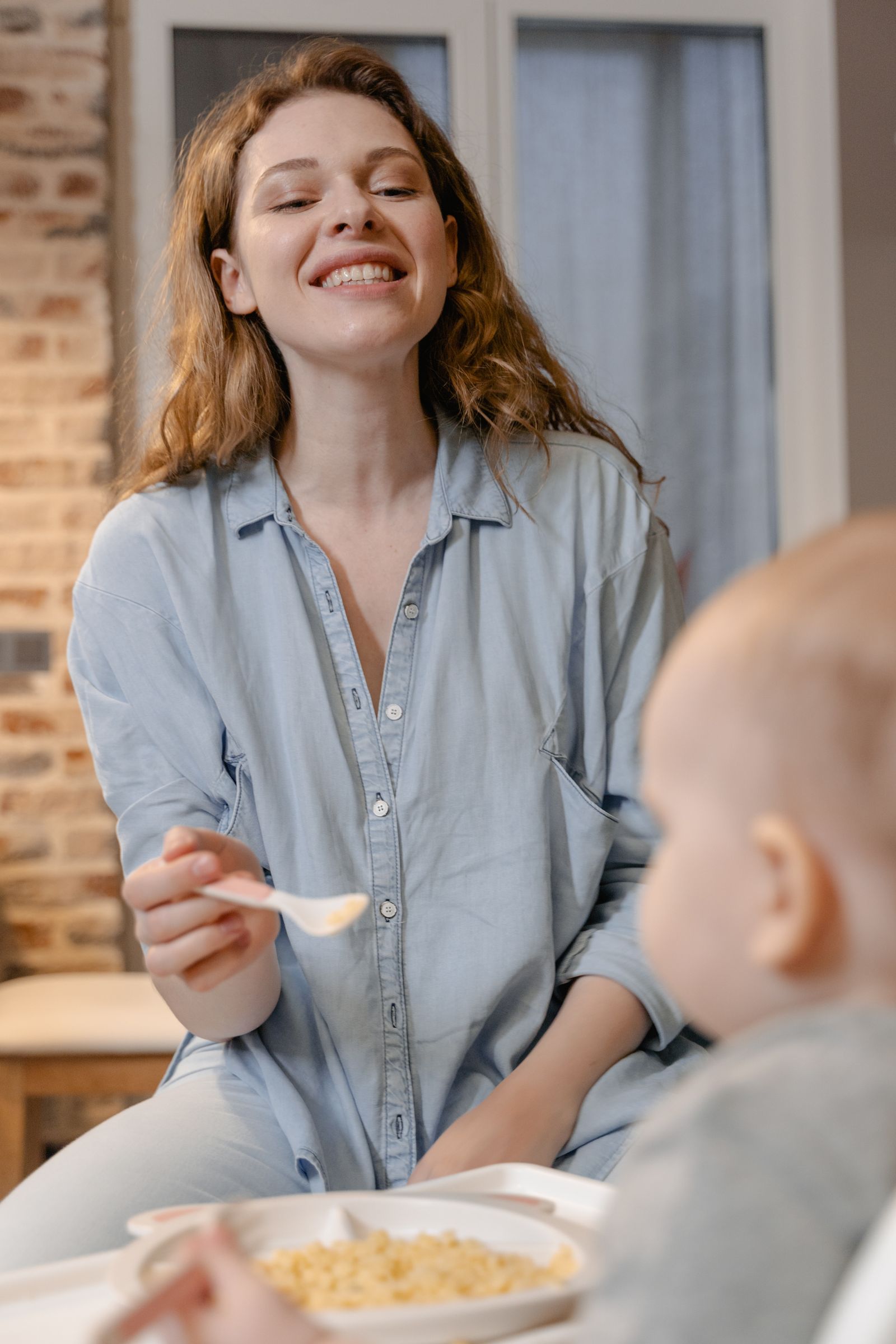 Madre che allatta un bambino con un cucchiaino